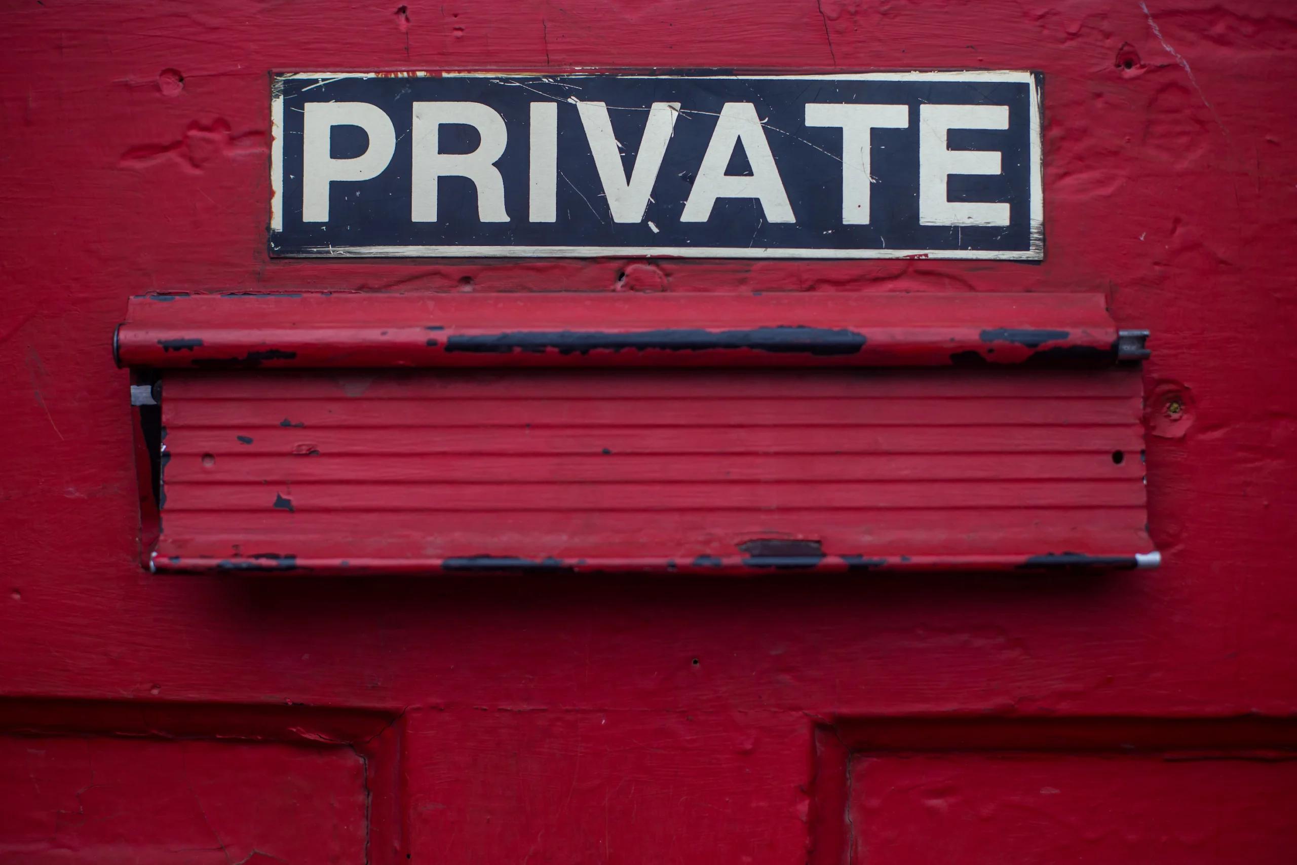 A red door with the word 'Private' painted on it